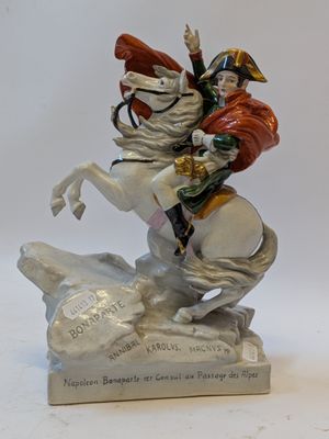 a figurine of a man riding a horse on a rock