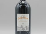 la bouteille de vin rouge est posée sur une surface blanche