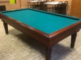 une table de billard placée au milieu d'une pièce