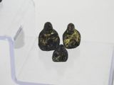 three small figurines sitting on top of a clear shelf