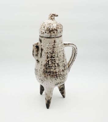a white coffee pot that is sitting on a table