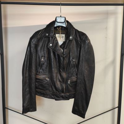 une veste en cuir noir suspendue à un portant dans une pièce