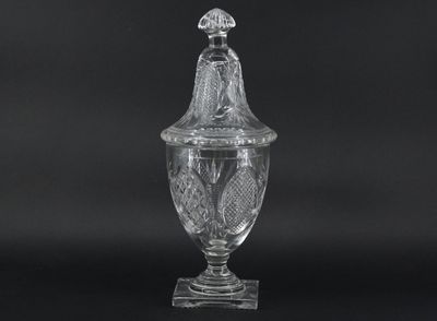 un bocal en verre transparent muni d'un couvercle et surmonté d'un oiseau