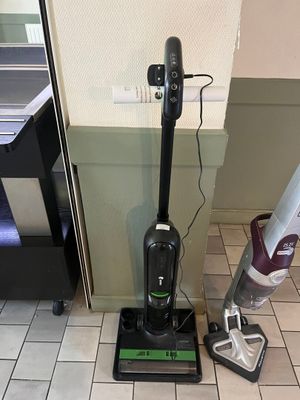 un aspirateur posé par terre, à côté du sol