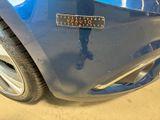 a close up of a blue car with a sticker on it