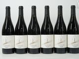 six bottles of wine are lined up in a row on a table