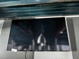 un téléviseur à écran plat suspendu au plafond dans une pièce