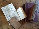 several old books sitting on top of a wooden floor on top of a hard wood floor
