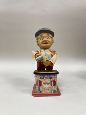 figurine représentant un homme assis sur une boîte, un journal à la main