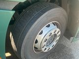 a green truck with a flat tire parked on the street