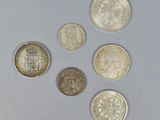 four different types of coins sitting on top of a white surface