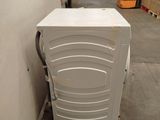 a white washing machine sitting on a pallet in a warehouse