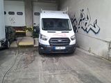 une camionnette blanche garée dans un garage dont les murs sont couverts de graffitis