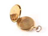 a gold pocket watch with a chain on a white surface
