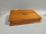 an old wooden box with a metal lid and a wooden base