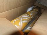 a cardboard box with a yellow and white pillow inside of it