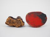 two pieces of red and black stone sitting next to each other