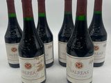 six bottles of wine are lined up in a row on a table
