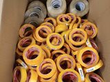 de nombreux rouleaux de ruban adhésif dans une boîte posée par terre
