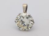 a close up of a diamond pendant on a white surface