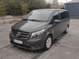 une fourgonnette Mercedes Classe V garée sur un parking devant un immeuble