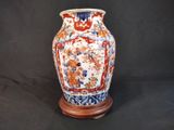 un vase posé sur un socle, sur fond noir
