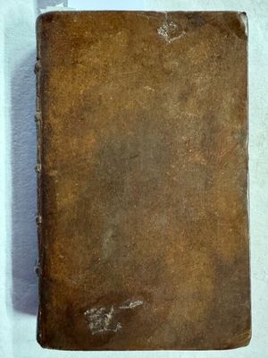 un vieux livre posé sur une table recouverte d'un tissu blanc