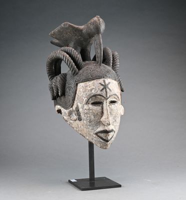 a close up of a sculpture of a head with horns on a stand