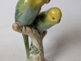a figurine of two parrots sitting on a branch