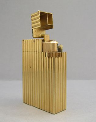un briquet doré posé sur une table blanche