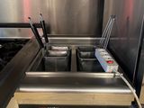 two deep fryers in the middle of a commercial kitchen