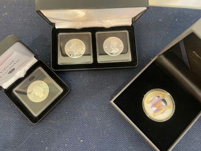 three gold coins are in a black box on a blue surface