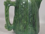 a green pitcher that is sitting on a table
