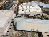 a pile of concrete blocks on the ground next to a fence