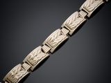 an antique carved bracelet with carved leaves on a black background