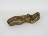 an old bronze figurine of a woman laying on her back