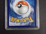 a pokemon card in a plastic case on a table