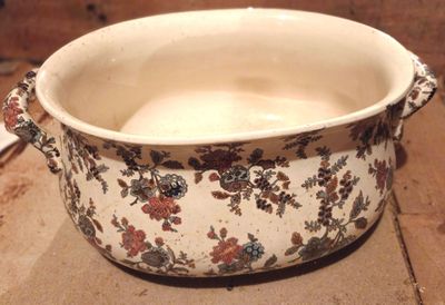un bol blanc orné de fleurs, posé sur une table
