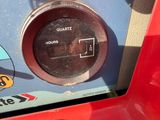 a close up of a clock on the side of a red car