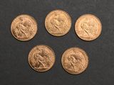 four different types of gold coins on a black surface