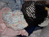 a pile of clothes that is sitting on a bed