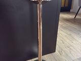 a tall silver candle holder on a wooden floor