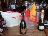 une bouteille de champagne et deux bouteilles de vin posées sur une table