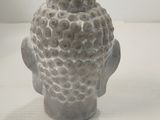 a small statue of a head on a white table