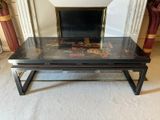 a black coffee table with a glass top on a carpeted floor