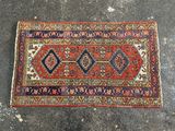 un tapis rouge et bleu posé sur un sol en béton