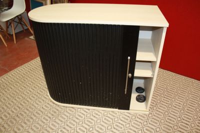 une petite armoire noire et blanche dans une pièce