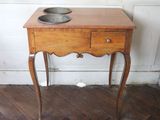 a small wooden table with a bowl on top of it