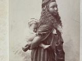 an old photo of a man with a beard holding a baby