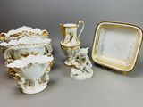 trois vases, une assiette et un plateau posés sur une table